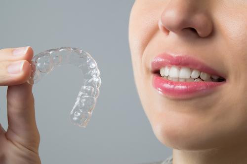 person holding invisalign clear aligner l cosmetic dentist clifton hill vic