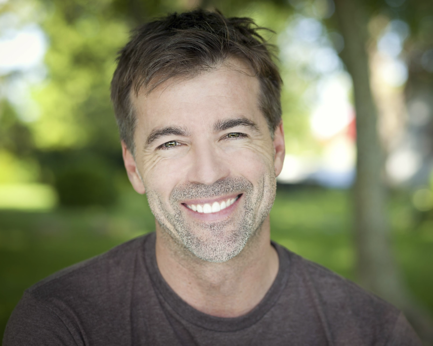 A man with a radiant smile at the park
