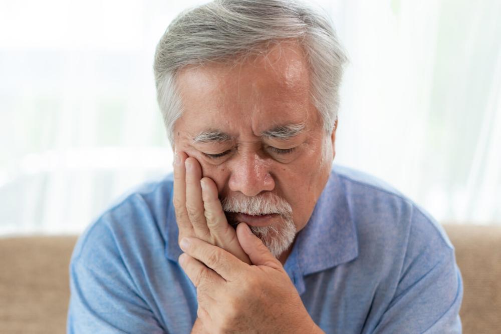 man holding jaw during emergency dental appointment