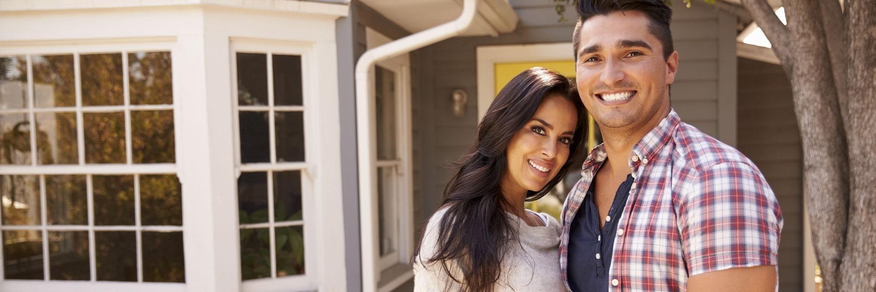 young couple standing outside home l dental implants thornbury