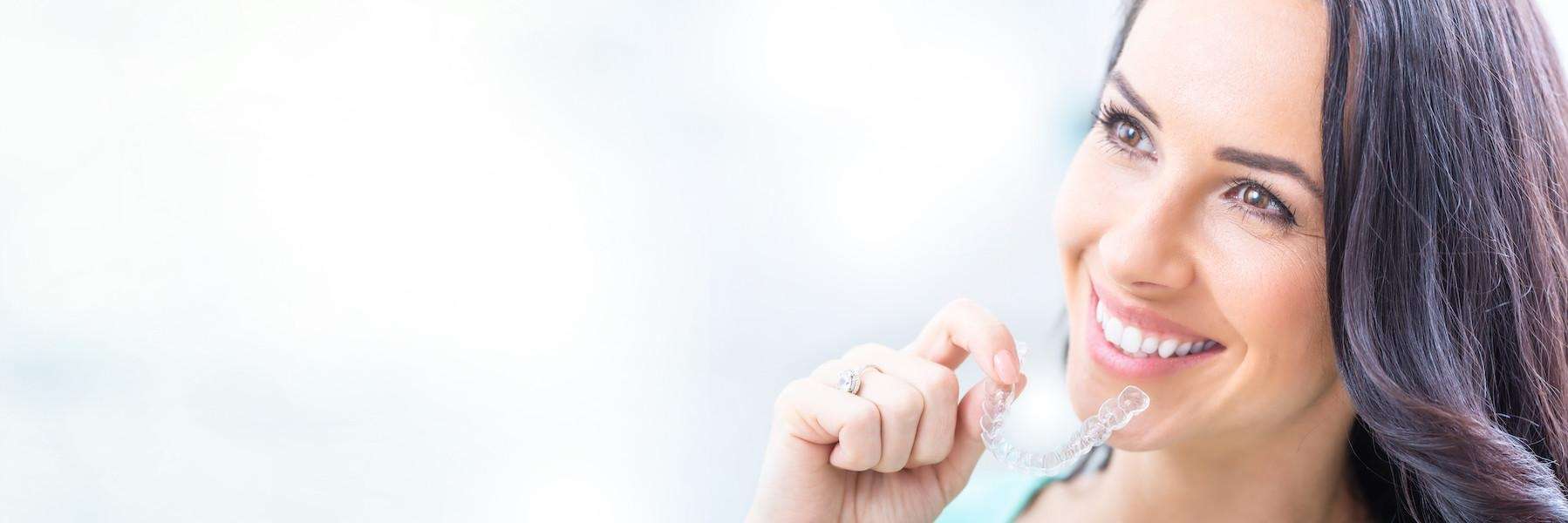 woman holding clear plastic aligner | dentist clifton hill vic