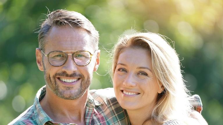man with glasses smiling with woman | dental implants thornbury