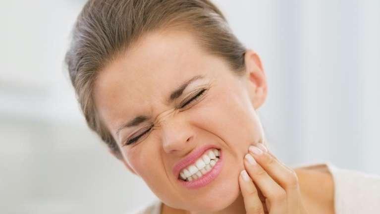 woman in pain holding jaw | emergency dentist clifton hill