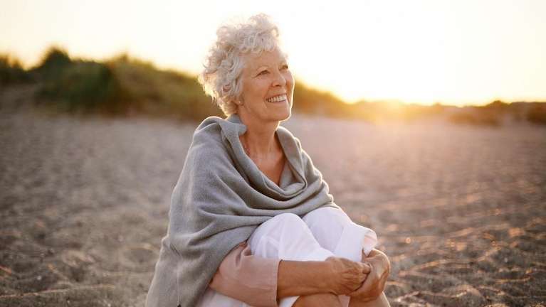 older woman in shawl on beach | all on 4 clifton hill vic