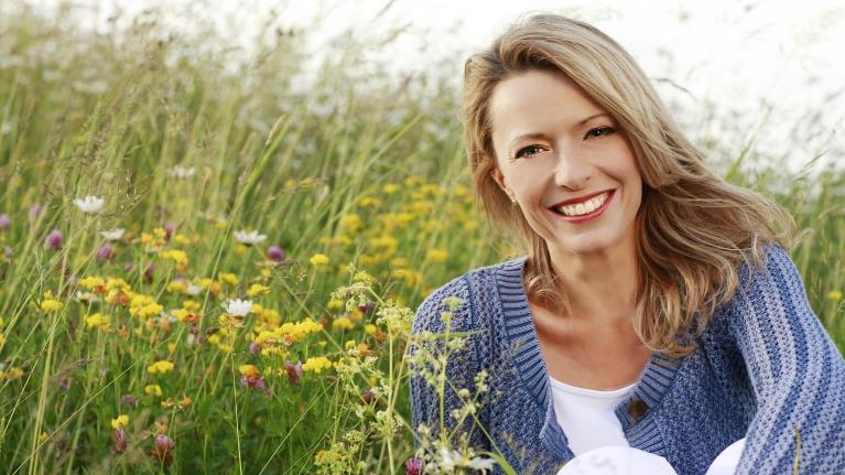 blonde woman smiling in a field l dentist northcote