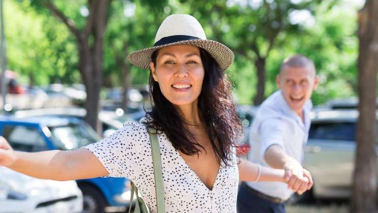 A laughing couple in a parking lot | Dentist Clifton Hill
